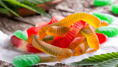 Gummy worms arranged with cannabis flower.