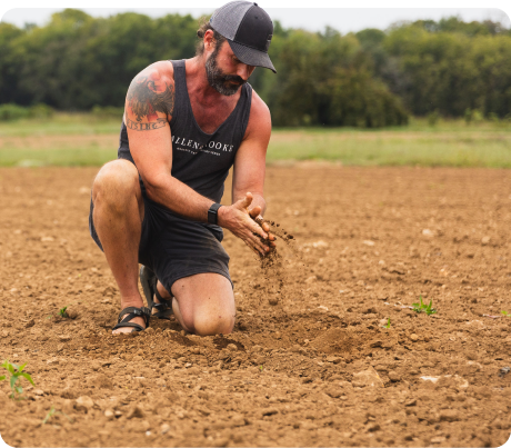 Farmer Dan inspecting soil on a dry-farmed hemp field used for organic live hemp terpenes.